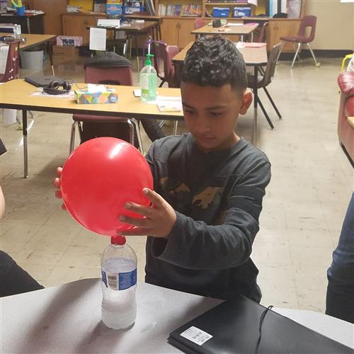 Student engaged in learning activity with balloon 
